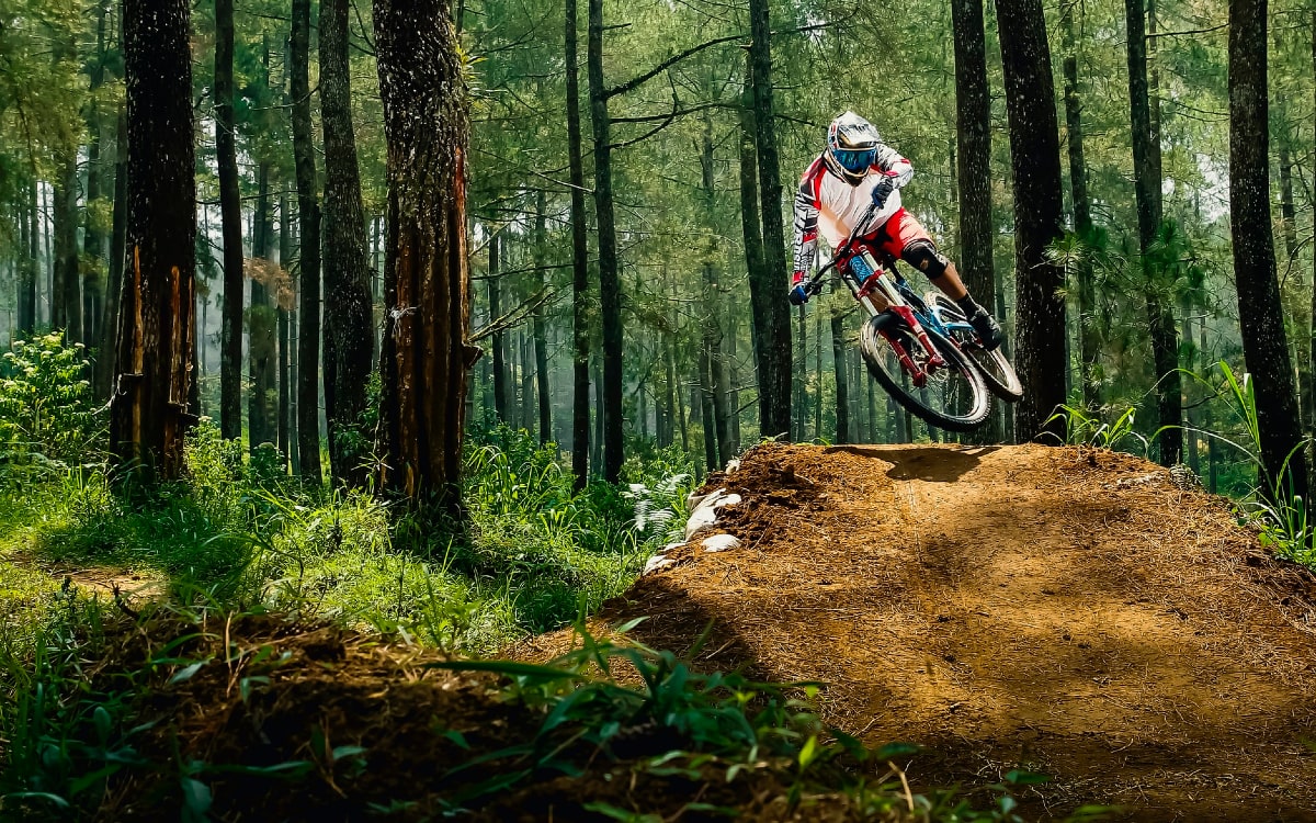 Downhiller springt &uuml;ber H&uuml;gel - Radtour planen und darauf vorbereitet sein