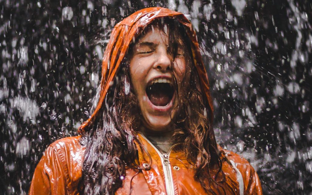 Eine Frau in Regenjacke steht im Regen