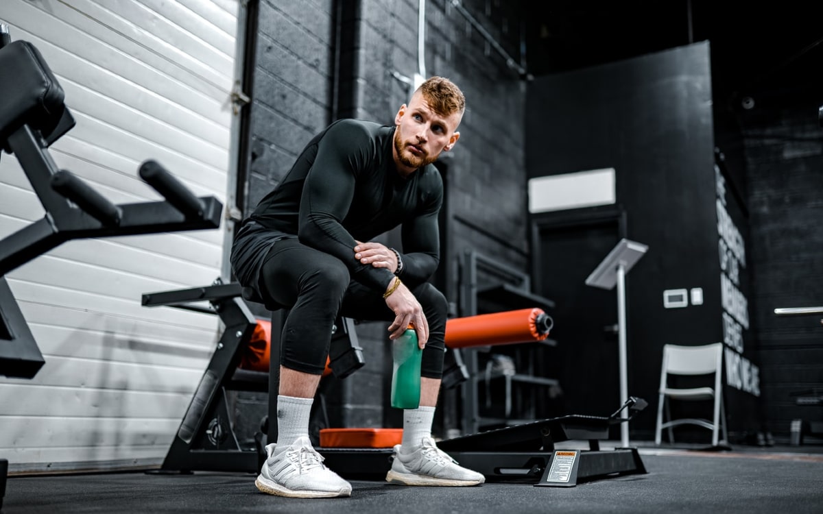 Mann sitzt mit einem isotonischen Getr&auml;nk in der Hand