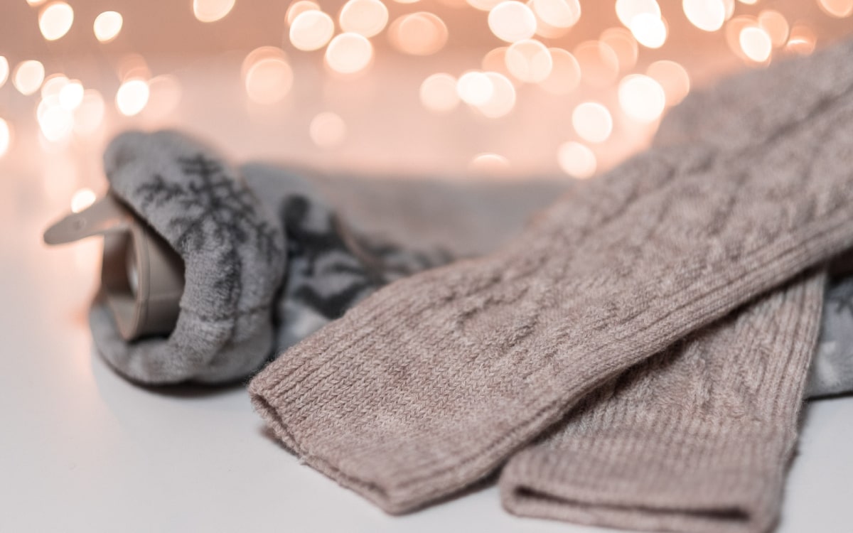 Warme Socken und eine Bettflasche helfen beim richtig heizen der Wohnung