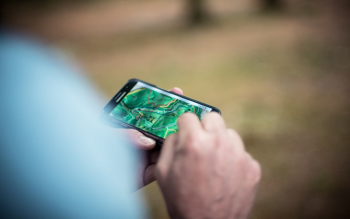 Eine Person kontrolliert auf seiner Wander App die Karte