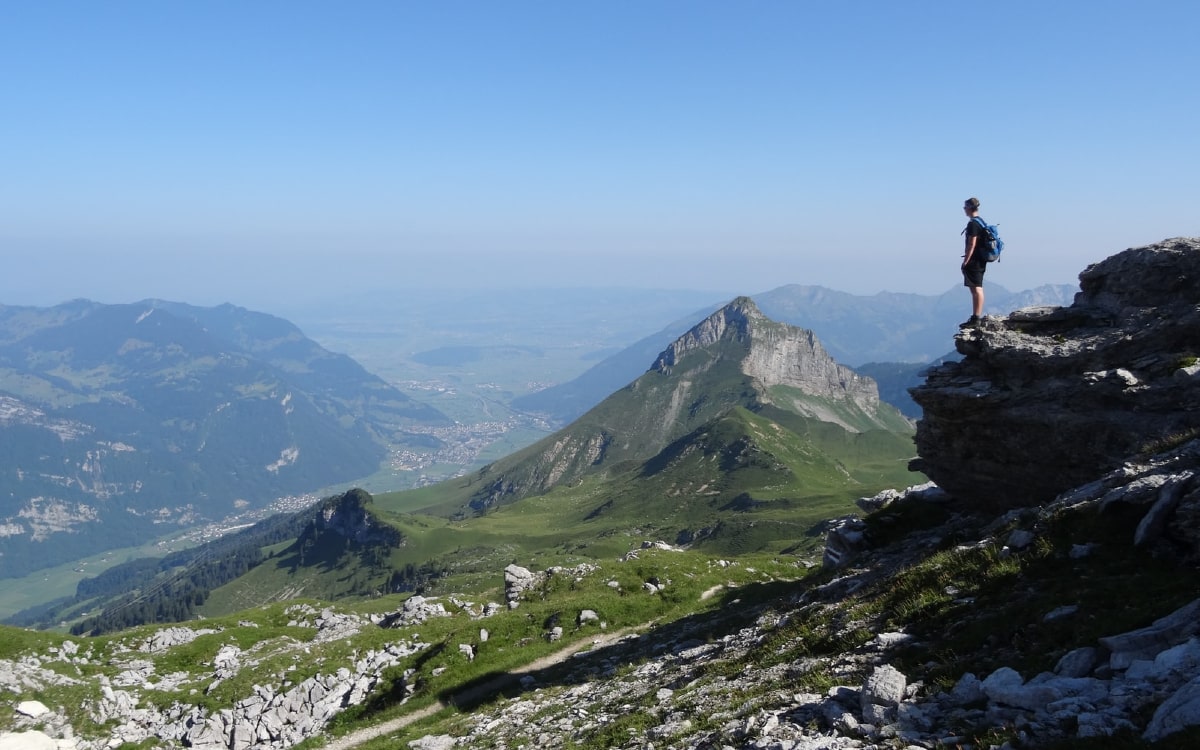 Eine Person steht auf einem Felsen und schaut in die Weite